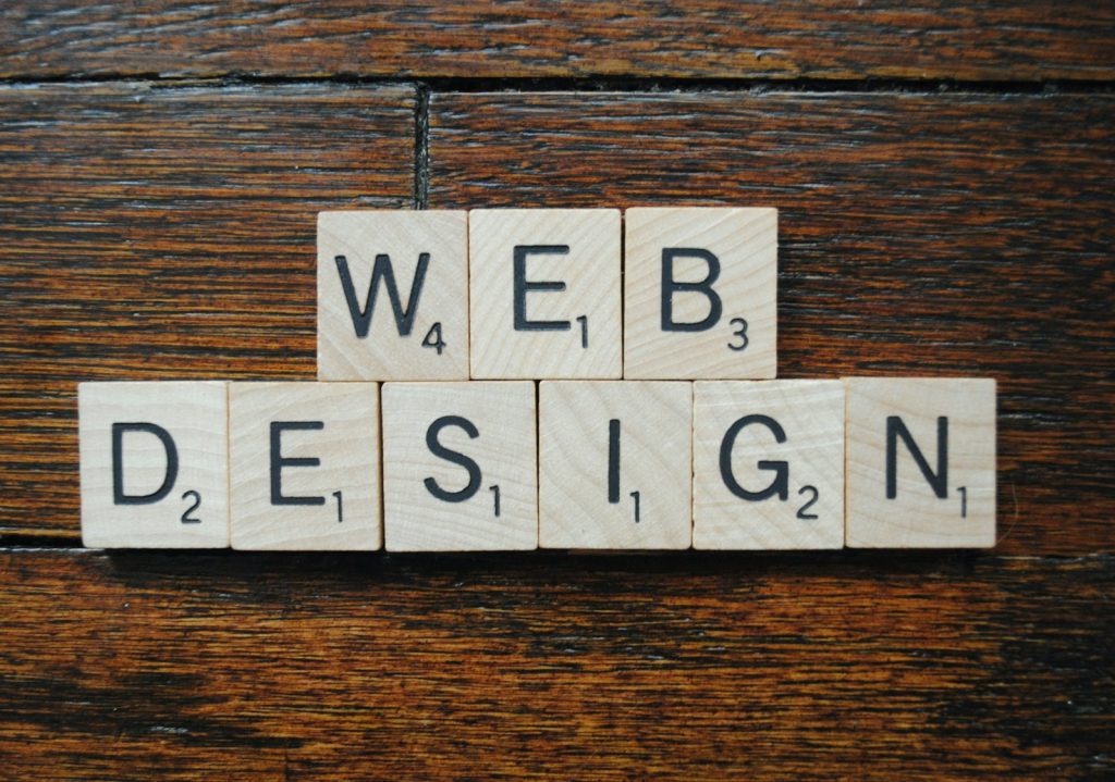 Scrabble tiles spelling web design on a wooden surface